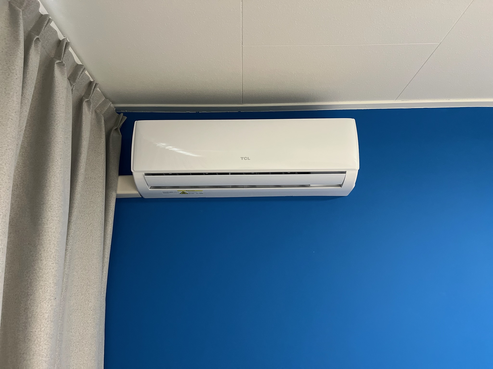 TCL binnenunit — kantoor met blauwe accentwand