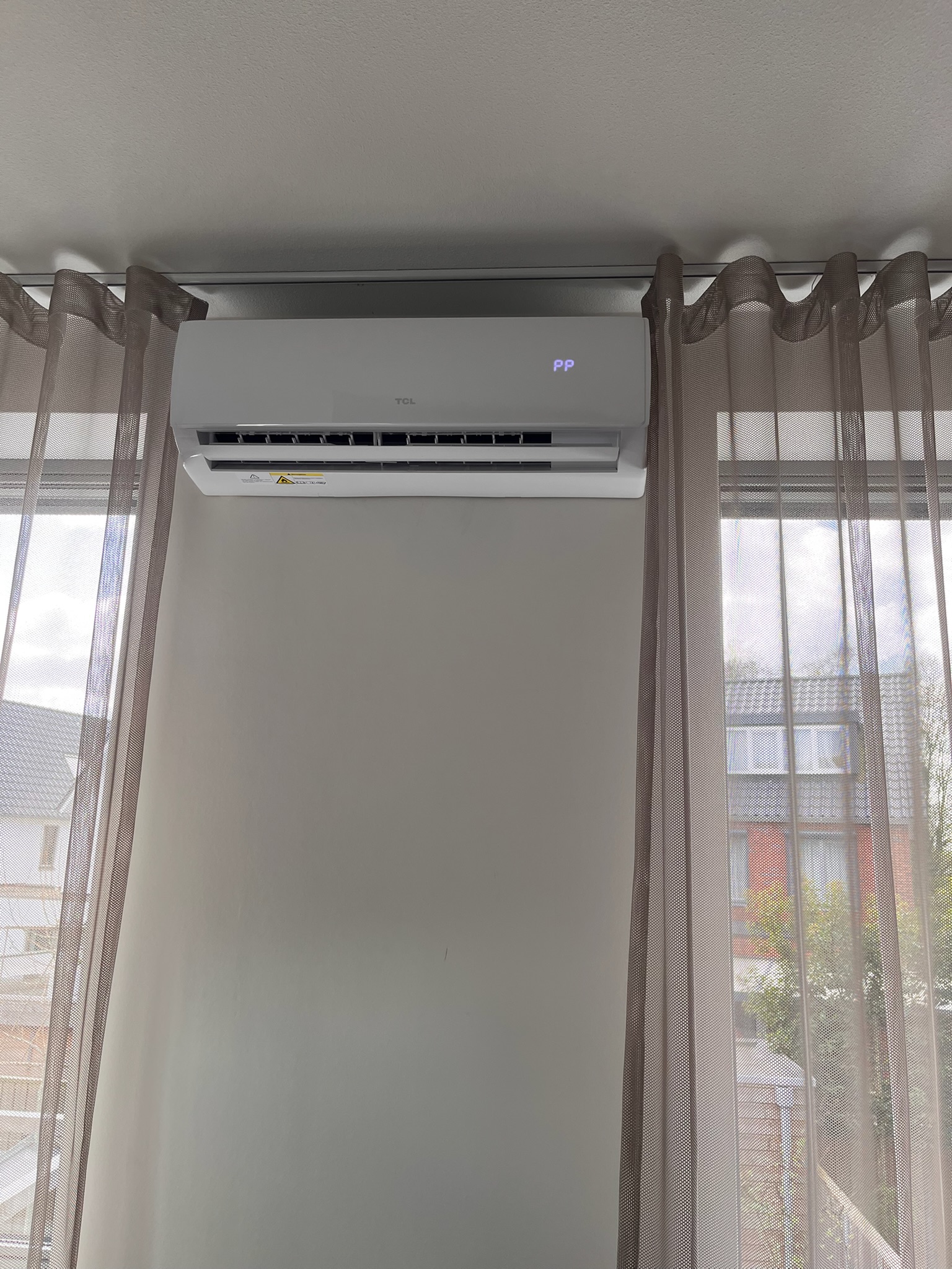 TCL binnenunit slaapkamer — uitzicht woonwijk