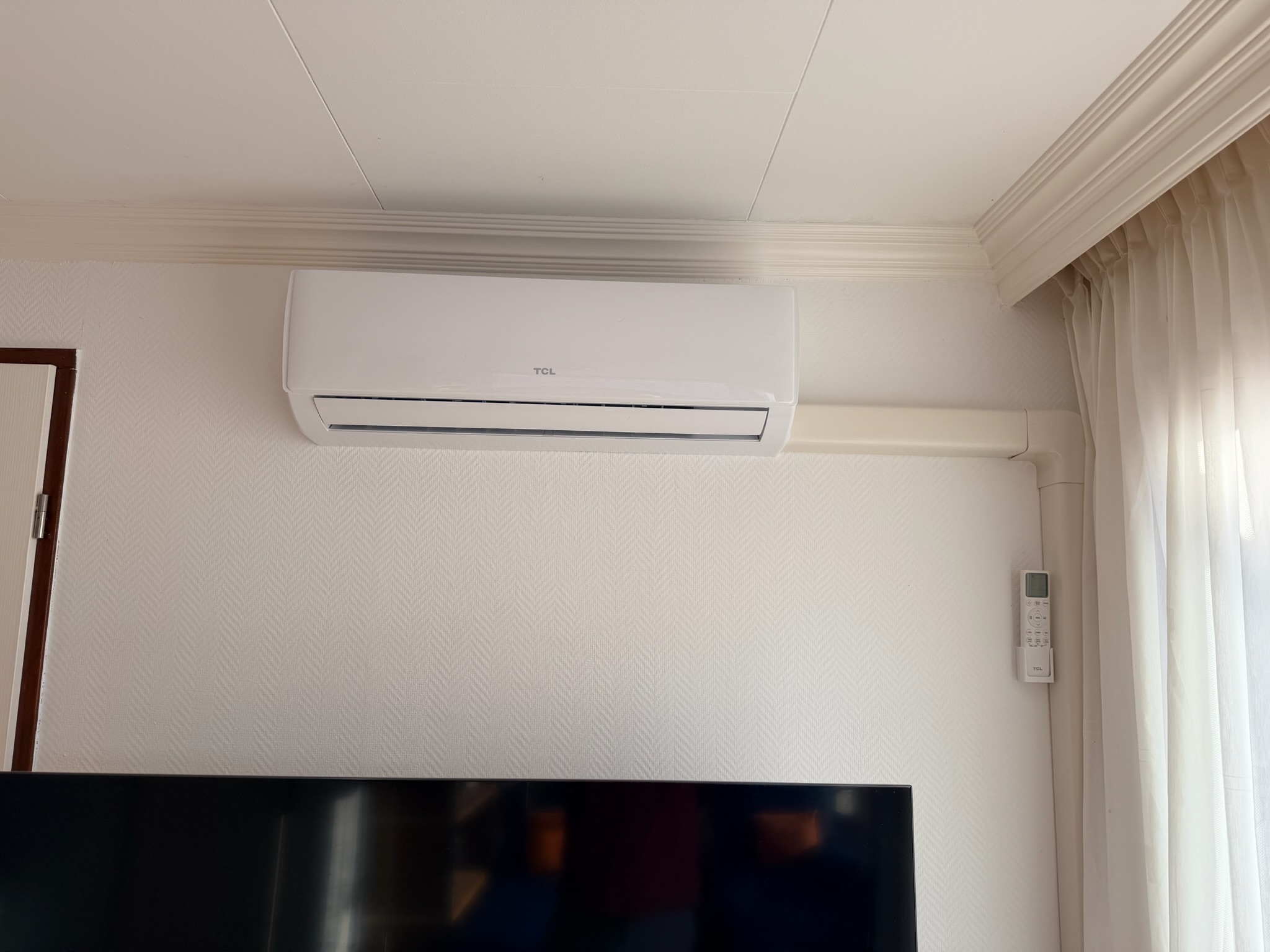 TCL binnenunit woonkamer — boven TV