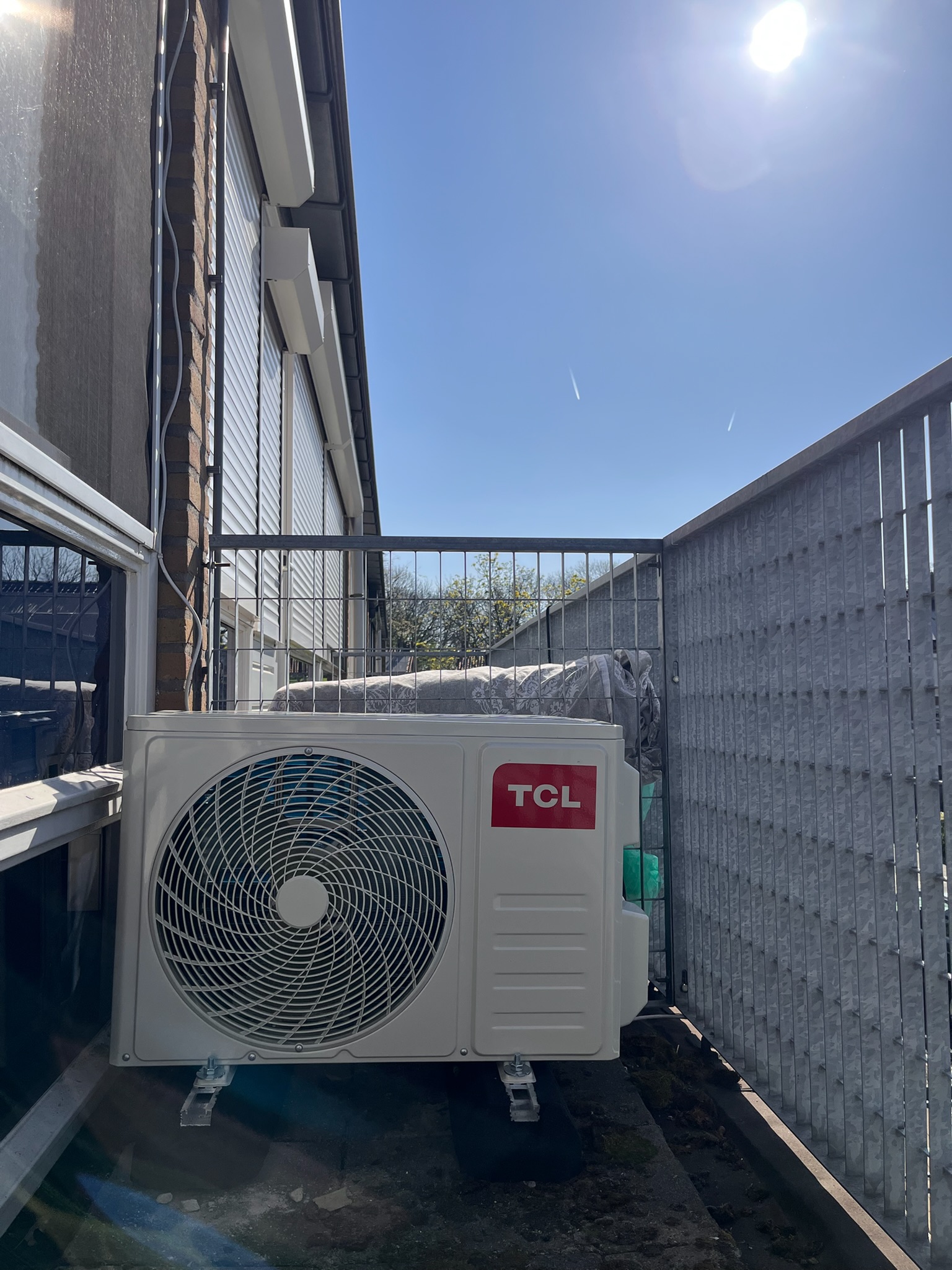 TCL buitenunit — hoog op zijgevel